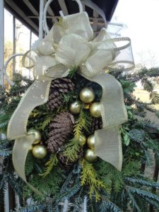 Frosted pine cones sprinkled atop a round evergreen wreath on burlap